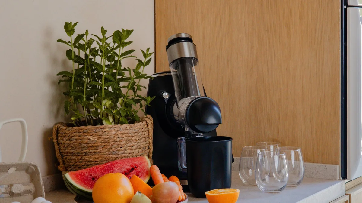 Extracteur de jus noir avec grand plat de pasteque, agrumes et carottes pour une famille